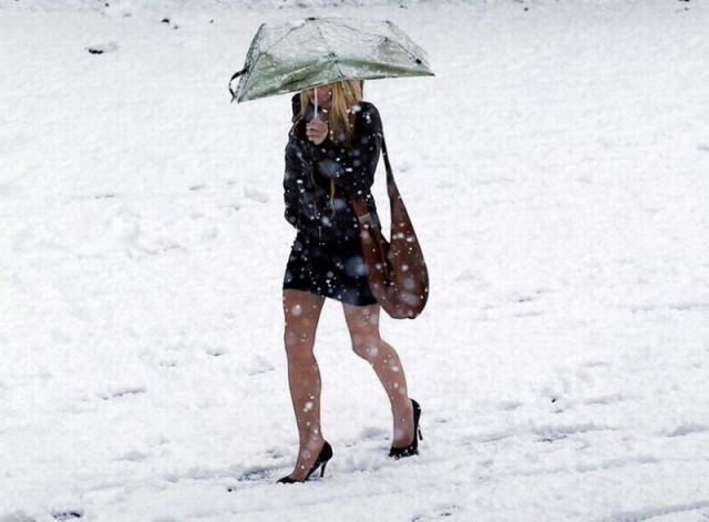 winter-wonderland-dressing-for-the-cold-a-woman-with-high-heels-walking-through-the-snow