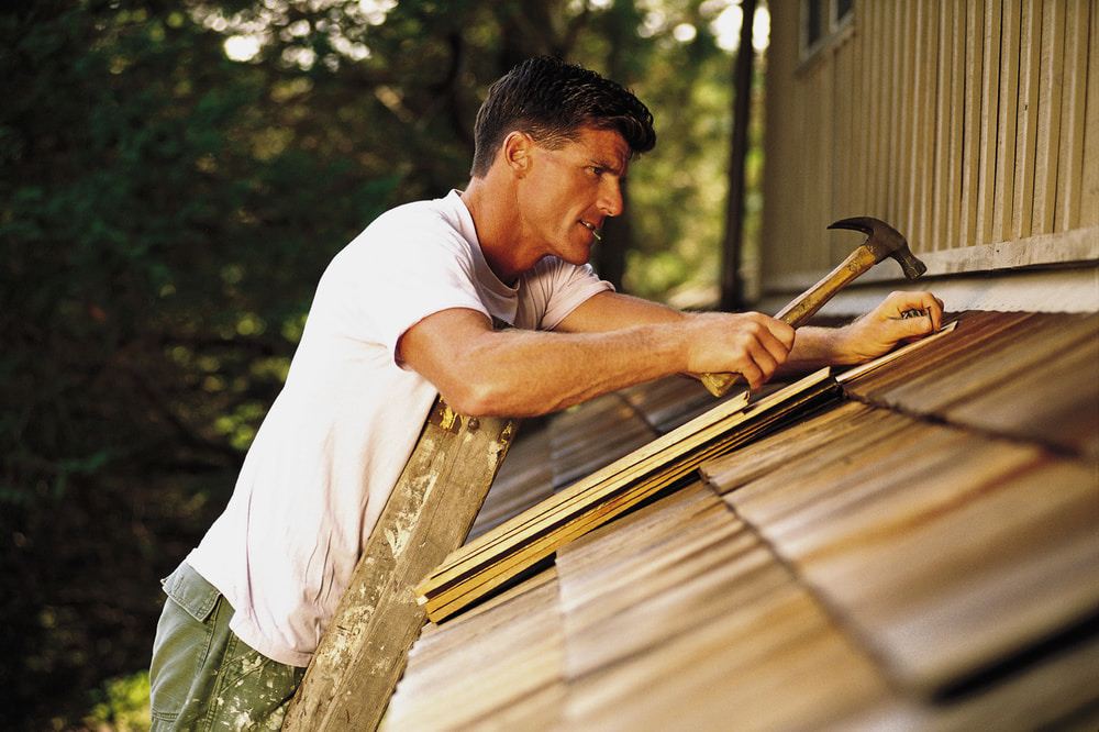 man-on-ladder-fixing-shingles